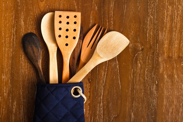 Portrait of different wooden kitchen tools with wooden background