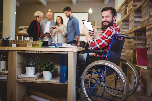 Portrait of disabled businessman using digital tablet