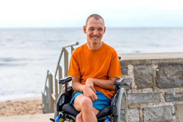 Портрет инвалида в инвалидной коляске на пляже во время летних каникул