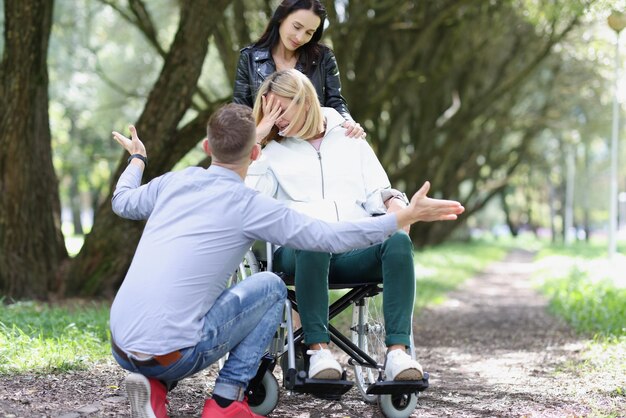 Foto ritratto di donna infelice disabile in sedia a rotelle con supporto amico e concetto di amicizia