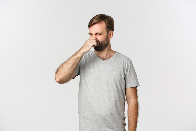 Portrait of disgusted caucasian man in gray t-shirt