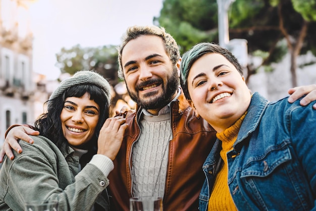 Ritratto di diversi amici che abbracciano il concetto di stile di vita dei giovani all'aperto con amici di genere misto che si divertono