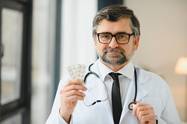 Portrait of doctor holding box of pills