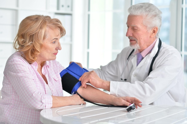 Photo portrait of a doctor measuring blood pressure of woman