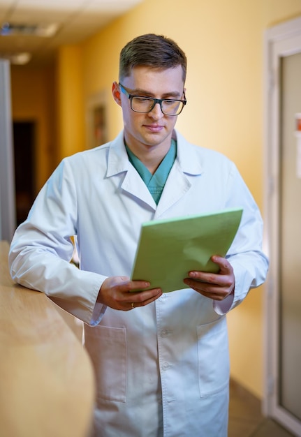 Portrait of a doctor or medical specialist Vertical photo Man in scrubs Hospital corridor background Closeup