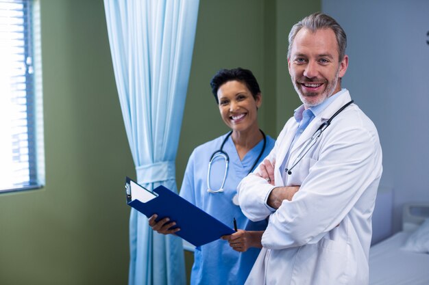 Portrait of doctor and nurse standing in ward