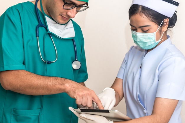 Portrait of Doctor and Nurse working together in team with tablet at hospital, teamwork.