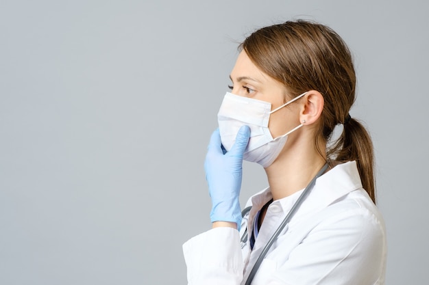 Portrait of doctor putting sterile mask isolated