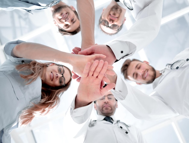 Foto ritratto di una squadra di medici che collega l'impilamento delle mani