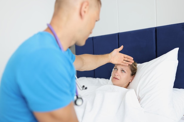 Photo portrait of doctor touching forehead of ill woman examining of patient sick female in bad