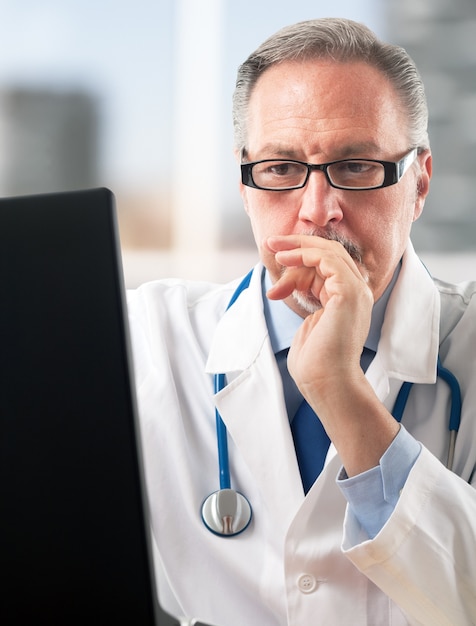 Portrait of a doctor using his computer