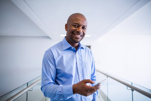 Portrait of doctor using mobile phone in corridor