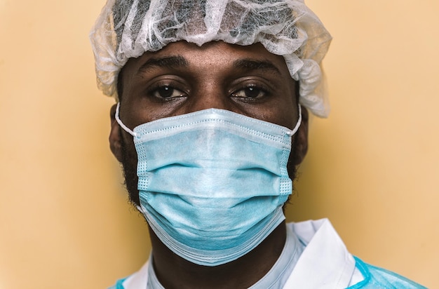portrait of doctor wearing mask standing against colored background