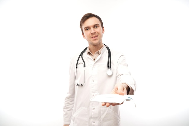Портрет врача в белом медицинском халате и защитной маске на белом фоне с копией пространства