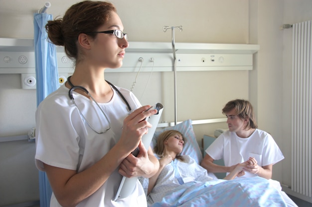  Portrait of a doctor with a her coworkers talking with a patient in the background 