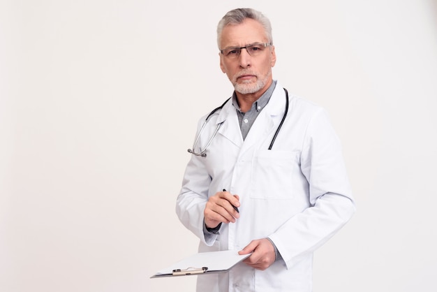 Портрет доктора при изолированные стетоскоп и доска сзажимом для бумаги.