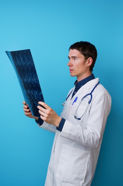 Портрет врача со стетоскопом на шее и рентгеном в руке