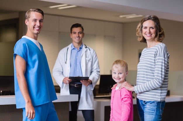 Portrait of doctors discussing medical report with mother and daughter