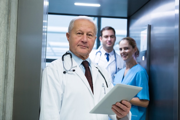 Portrait of doctors and surgeon standing in elevator