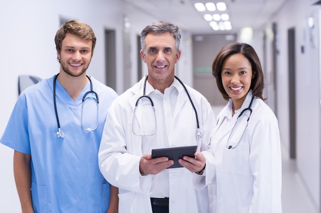 Portrait of doctors using digital tablet in corridor