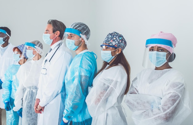 Foto ritratto di medici che indossano una maschera in piedi su uno sfondo bianco