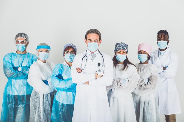 Photo portrait of doctors wearing mask standing against white background