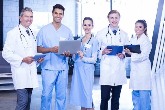 Portrait of doctors with digital tablet, laptop and medical report