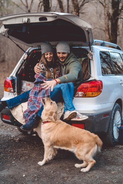 Photo portrait of dog sitting by car