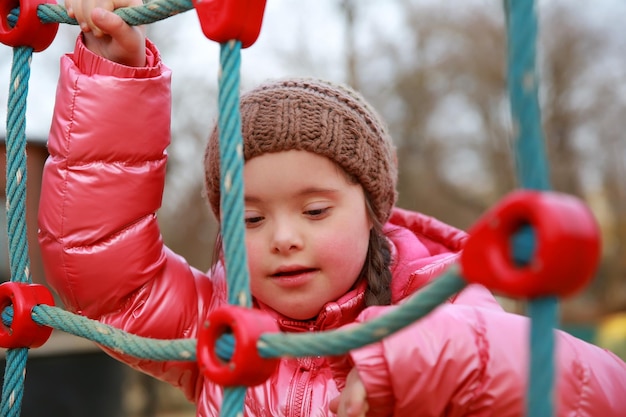 Portrait of down syndrome girl on the playground