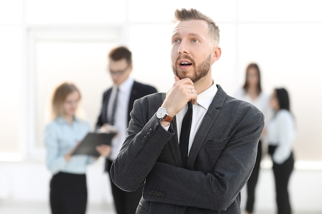 Portrait of a dreaming businessman on a blurred office background. business concept