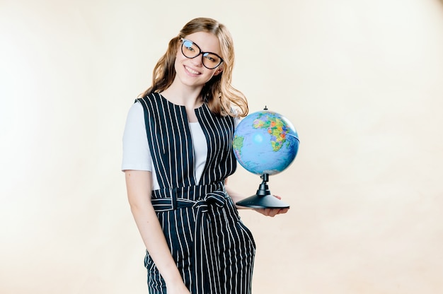 Portrait of a dreamy young business woman holding earth globe 