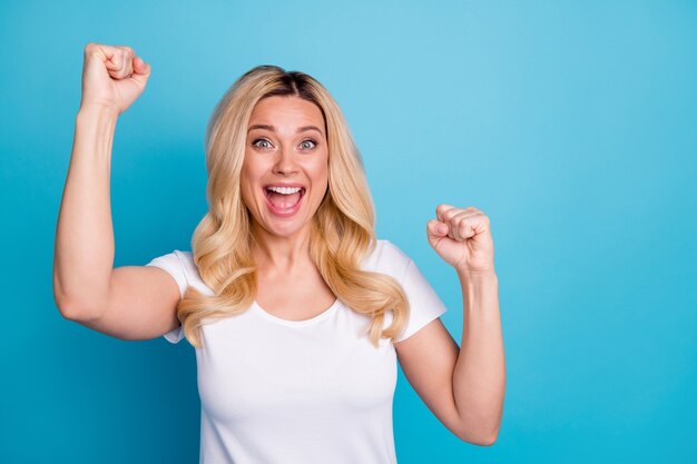 portrait of ecstatic crazy woman enjoy rejoice win raise fists