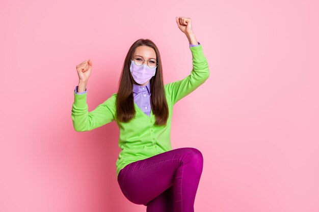 Portrait of ecstatic girl win raise fists wear medical mask respiratory isolated over pastel color background