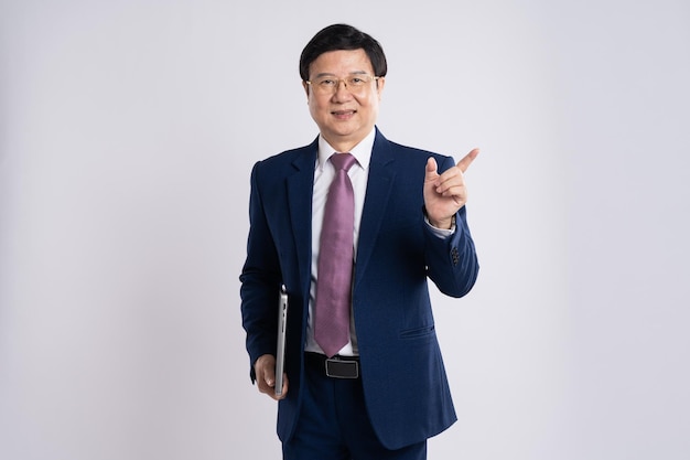 색 배경 에 포즈 를 취하고 있는 노인 아시아 사업가 의 초상화