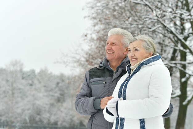 Portrait of elderly couple having fun outdoors in winter forest