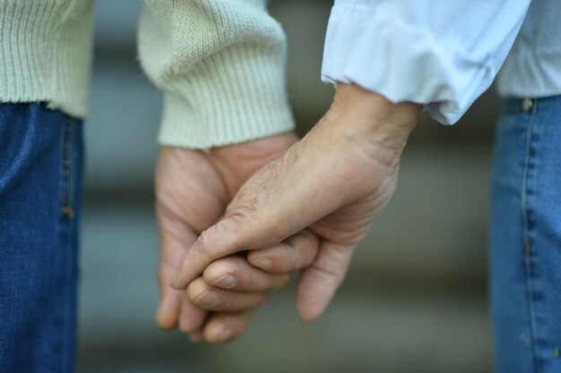 Portrait of elderly couple holding hands close up