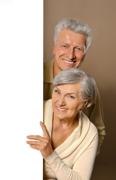 Portrait of an elderly couple  posing with board