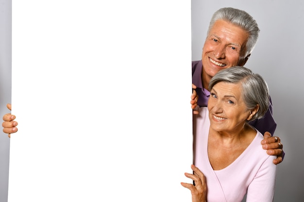 Portrait of an elderly couple  posing with board