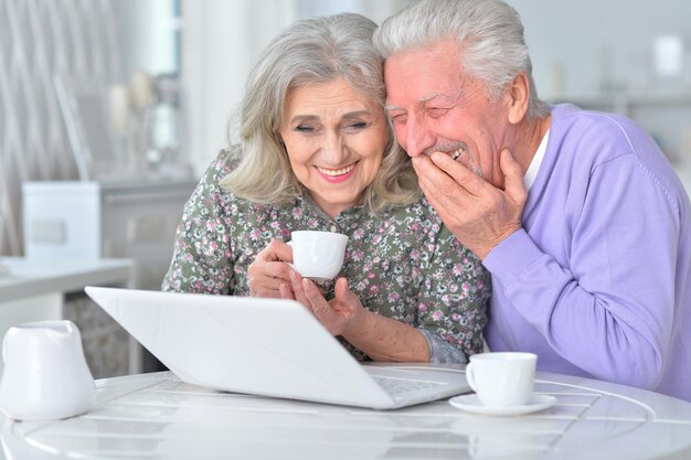 ノートパソコンを持っている老夫婦の肖像画