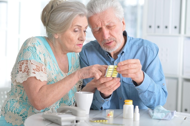 Portrait of an elderly couple with pills