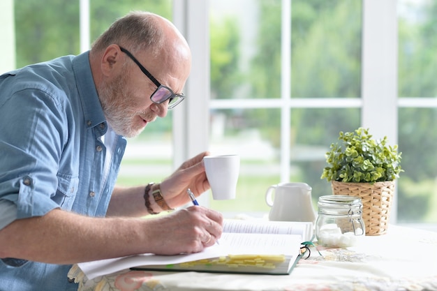 Portrait of elderly happy man with book