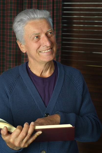 Portrait of elderly happy man with book