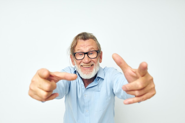 Portrait elderly man in blue shirts gestures with his hands isolated background