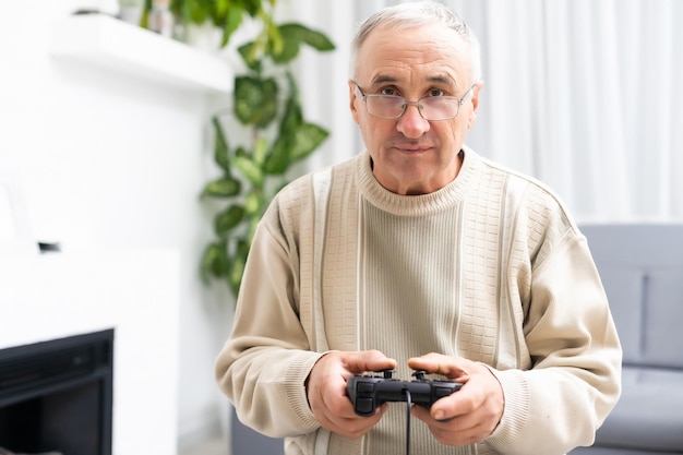 Portrait of elderly man playing video games with joystick