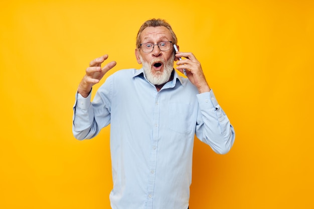 Портрет пожилого мужчины, разговаривающего по телефону, позирующего крупным планом на изолированном фоне