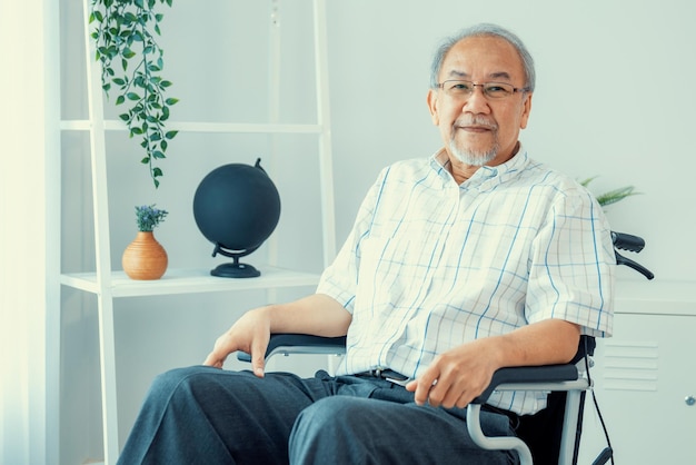 Portrait of an elderly man in a wheelchair contented and alone at home