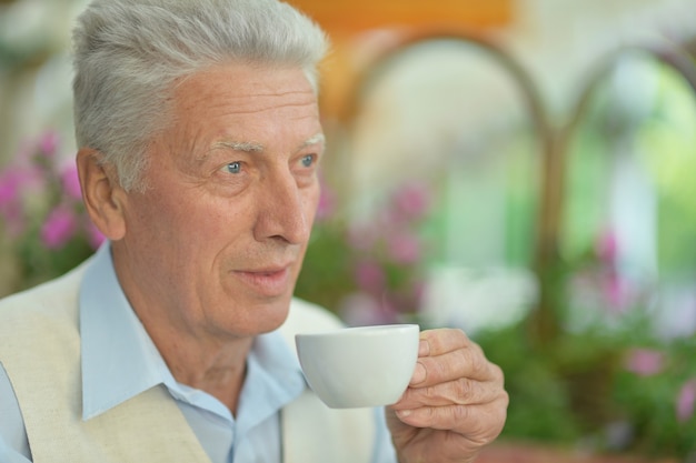 Portrait of an elderly man with cup of coffee