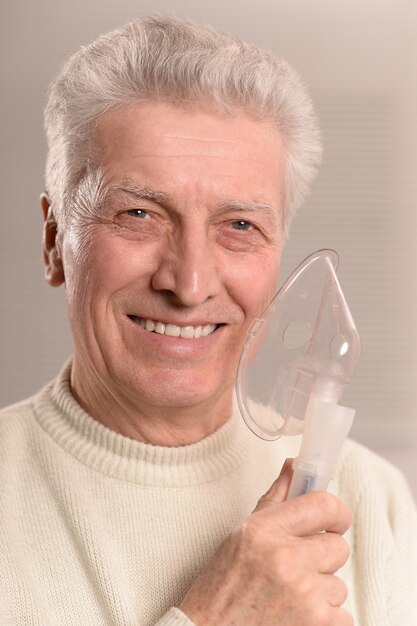 Portrait of elderly man with flu inhalation