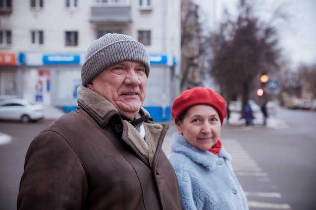 Photo portrait of elderly man with mature wife on winter city street