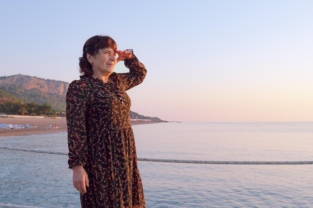 Portrait of an elderly woman on the beach in the light of the rising sun